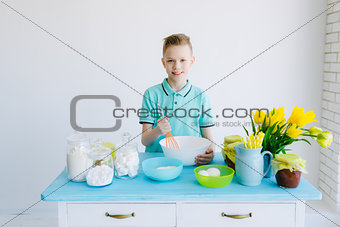 The child preparing dough in the kitchen