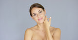 Pretty bare shouldered woman with fingers on neck