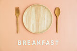 Top view of wooden cutlery with breakfast word