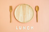 Top view of wooden cutlery with lunch word