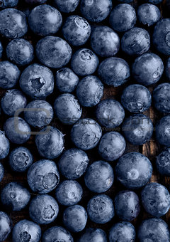 Blueberries on grunge wooden kitchen board close up