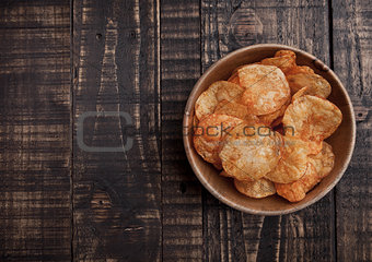 Bowl with potato crisps chips on wooden board