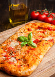 Pizza bread with tomatoes and olive oil on wooden board