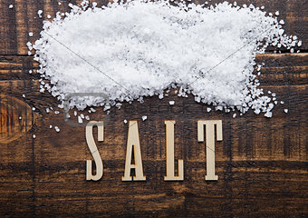 Salt on grunge wooden board with letters below