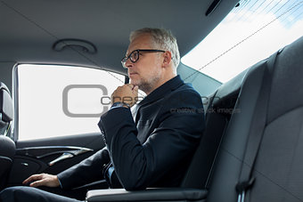senior businessman driving on car back seat