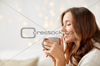 happy woman with cup of tea or coffee at home