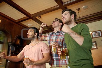 friends with beer watching sport at bar or pub