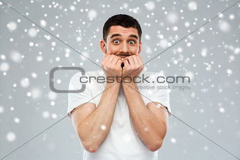 scared man in white t-shirt over snow background