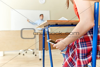 student girl with smartphone texting at school