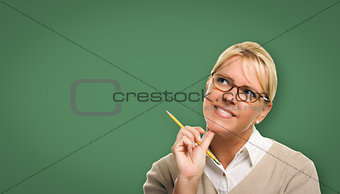 Attractive Young Woman with Pencil In Front of Blank Chalk Board