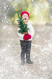 Baby Girl In Mittens Holding Small Christmas Tree with Snow Effe