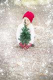 Girl In Red Mittens and Cap Near Small Christmas Tree with Snow 