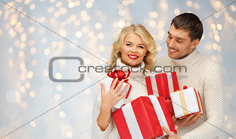 smiling man and woman with presents over lights