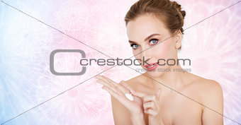 happy young woman with moisturizing cream on hand