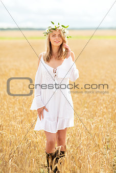 happy young woman in flower wreath on cereal field
