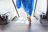 woman legs stepping on an escalator