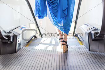woman legs stepping on an escalator