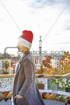 tourist woman in Santa hat at Guell Park looking into distance