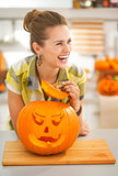 housewife in kitchen with a big orange pumpkin Jack-O-Lantern