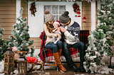 Young family with a baby boy sitting on the bench in winter decorations