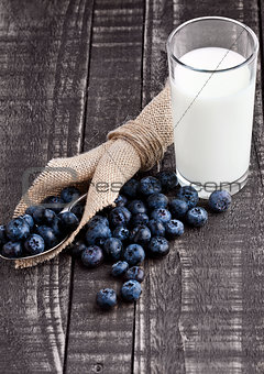 Blueberries  on spoon woth milk glass on wood tale