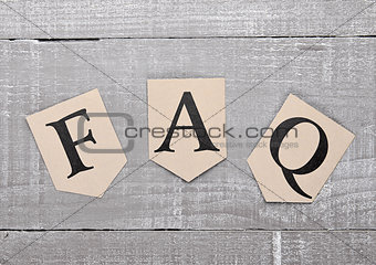 FAQ paper letter symbol motivation on wooden board