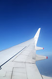 Wing of an airplane on blue sky