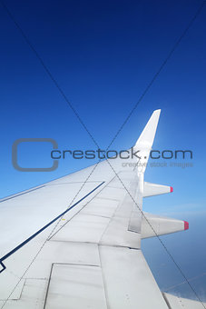 Wing of an airplane on blue sky