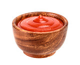 Ketchup or tomato paste in wooden bowl isolated on white
