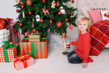 The child with a gift near the Christmas tree