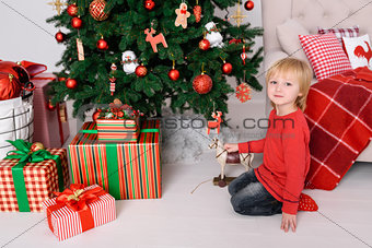 The child with a gift near the Christmas tree