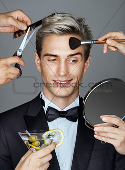 Smiling elegant man and many hands making different beauty salon services