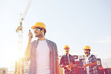 group of smiling builders in hardhats with radio