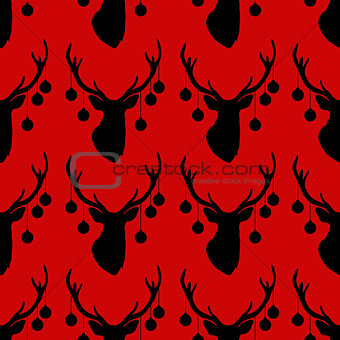 Seamless pattern with silhouette of deer head  christmas tree toys on horns  red background.