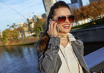 smiling fashion-monger talking on smartphone near Eiffel tower