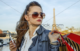 trendy woman with shopping bags in Paris looking into distance