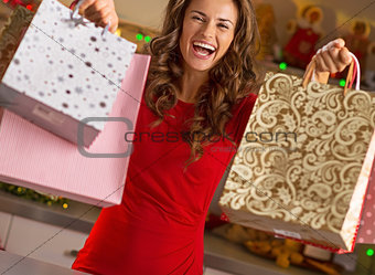 Happy young woman showing shopping bags in christmas decorated k