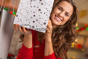 Smiling young woman showing christmas shopping bag