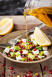 Fresh  green salad with pomegranate seeds, cucumber and feta che