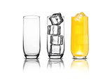 Glass of orange soda with ice cubes empty glass