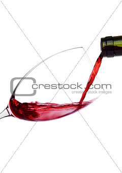 Pouring red wine from bottle to glass isolated