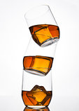 Glasses of whiskey with ice cubes and reflection