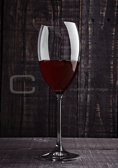 Glass of red wine with reflections on wooden board