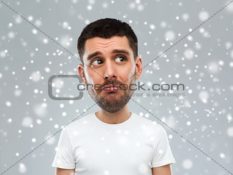 unhappy young man over snow background
