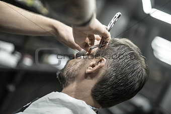 Trimming beard in barbershop