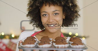 Smiling happy woman with tray of fresh muffins
