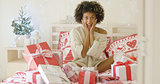 Excited young woman with a bed full of Xmas gifts