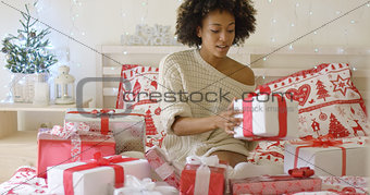 Young woman sitting in bed surrounded by gifts