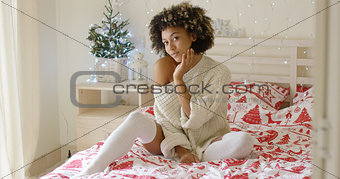Sexy young woman relaxing on her bed at Christmas