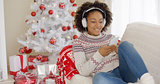 Attractive woman listening to music at Christmas